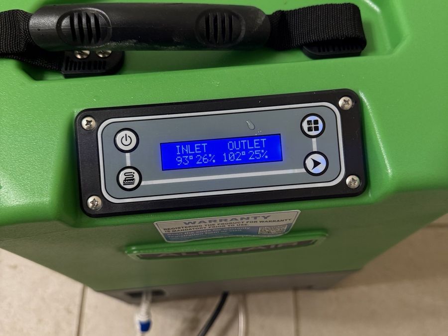 A dehumidifier display showing inlet and outlet temperature and humidity readings
